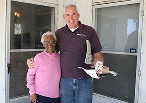 Volunteer with Meals on Wheels brings a meal to an older woman